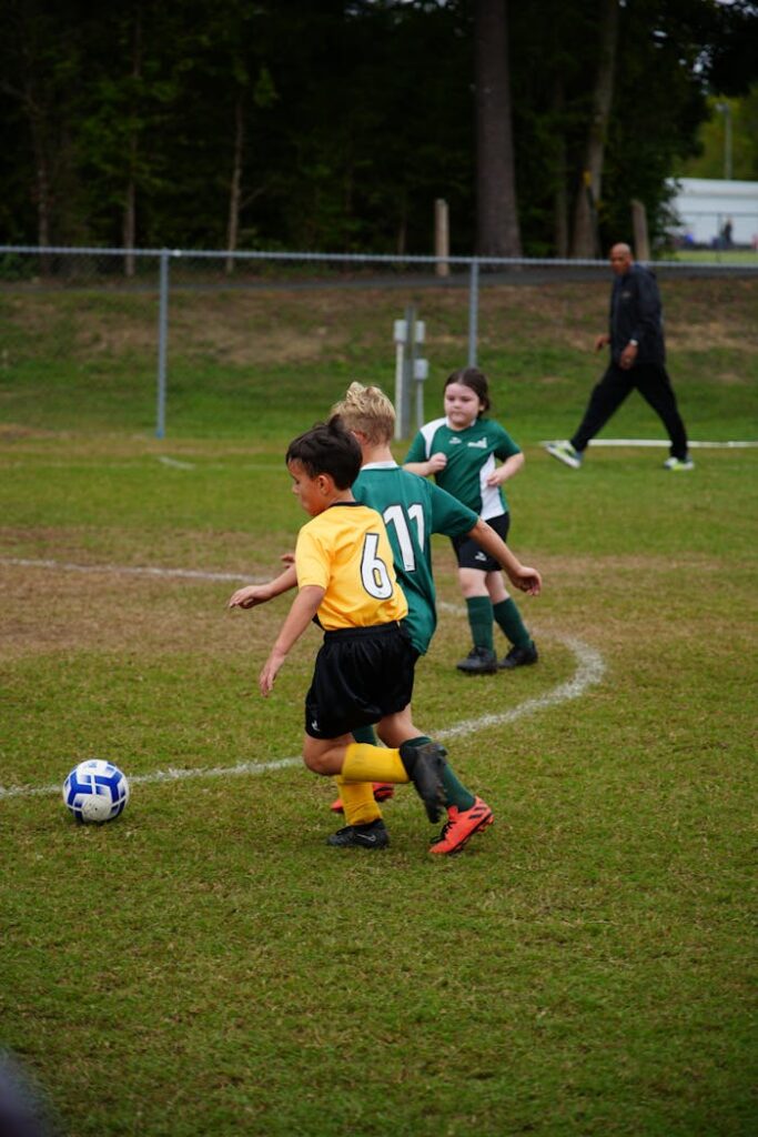 Kids playing an intense soccer match outdoors in vibrant sportswear.
